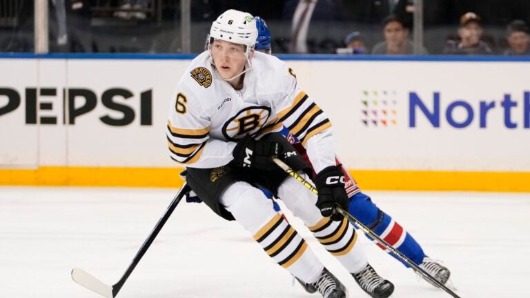 Boston Bruins' Mason Lohrei looks to pass the puck away from New York Rangers' Kaapo Kakko during the second period of an NHL preseason hockey game Thursday, Oct. 5, 2023, in New York.